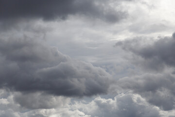 Dramatic, overcast sky filled with dark, textured clouds, creating a moody and atmospheric scene