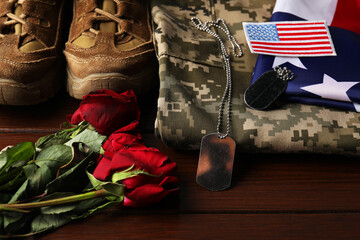 Veterans day. USA army patch, tokens, American flag, roses and military uniform on wooden table,...