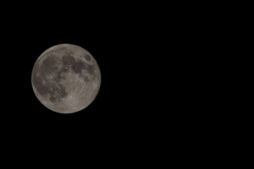 The full moon surface close up that lights up in the night.