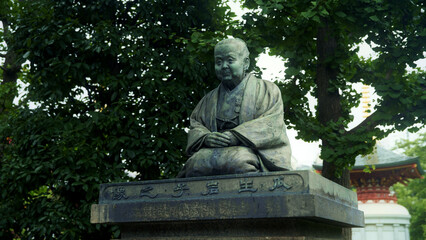 Ancient bronze statue of Uryu Iwako under trees