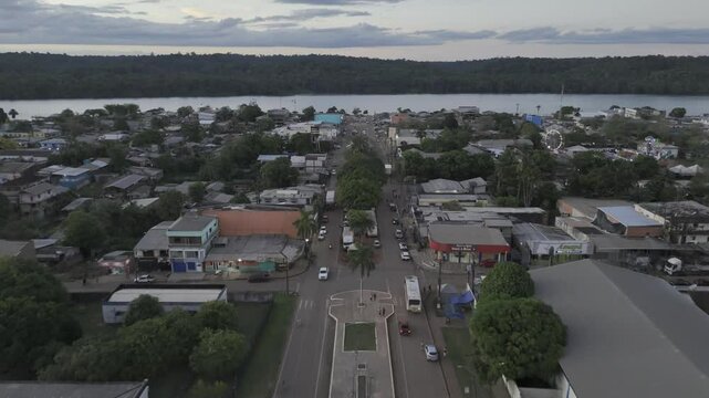 Drone flies along main street toward river in Oiapoque, Amapá, Brazil