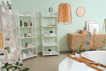 Obraz premium Interior of modern stylish bathroom with houseplants and different cosmetic products on shelving units