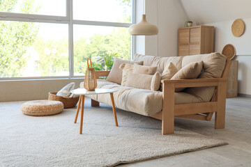 Interior of living room with cozy sofa, coffee table and hanging lamp