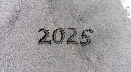 Business concept of 2025 new year symbol. Concept 2025 happy new year written on beautiful ocean sand beach. Beautiful ocean sand beach background, copy space. Business 2025 happy new year concept.