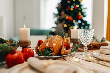 Christmas dinner table setting with roast chicken as centerpiece