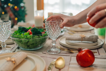 Woman setting table for christmas eve dinner with family