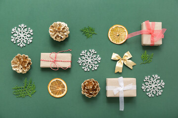 Christmas composition with cones, orange slices, gifts, snowflakes and bows on green background. Top view