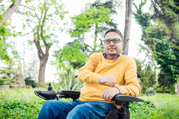 man sitting in wheelchair working on laptop online