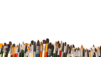 Mix of paint brushes in a row isolated on a white background.
