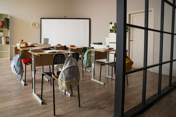 Interior of classroom with school desks and projector screen
