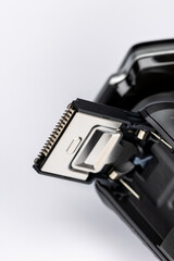 Beard shaver on a white background. Macro close-up of the trimming cutting blades. Photo taken in artificial light with clearly visible details of the shaver