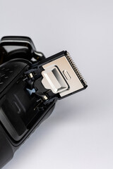 Beard shaver on a white background. Macro close-up of the trimming cutting blades. Photo taken in artificial light with clearly visible details of the shaver