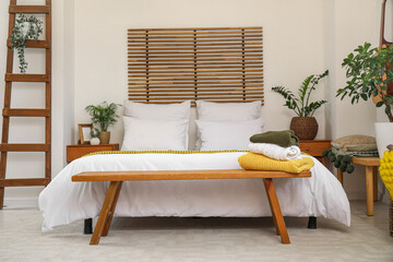 Stylish interior of bedroom with bench and ladder