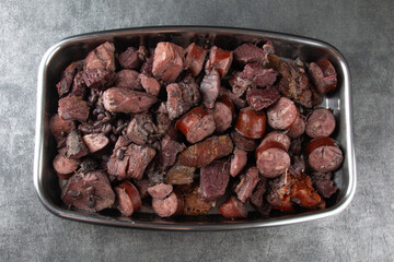 Traditional Brazilian feijoada. Tray with meat and sausage ingredients