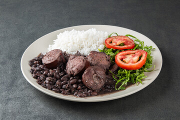 Plate with traditional Brazilian Feijoada with a gray background