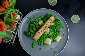 Pan fried salmon with warm green spring salad, fresh and healthy lunch, top view