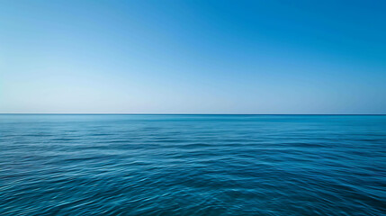 Fototapeta premium Deep blue ocean with a clear horizon. The water is calm and serene, with gentle waves rippling on the surface.