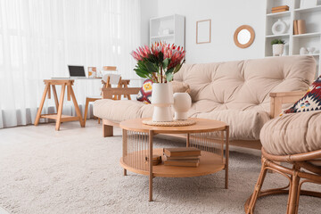 Protea flowers in vase on coffee table in living room
