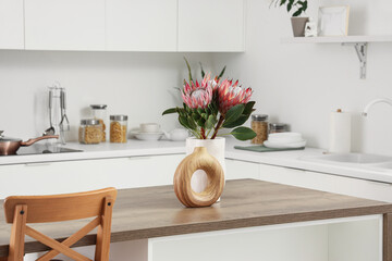 Protea flowers on dining table in kitchen