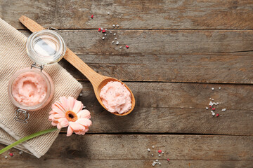 Composition with natural body scrub, clean towel and gerbera flower on wooden background