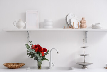 Red dahlia flowers in sink in kitchen