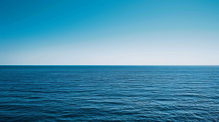 Obraz premium Deep blue ocean with a clear blue sky. The water is calm and still.