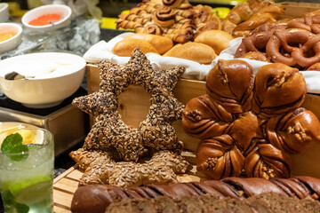 Festive bread display with star and wreath-shaped loaves, assorted holiday artisan breads, rustic bakery arrangement for holiday buffet