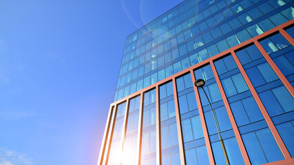 Modern stylish architecture. Symmetrical blue glass building in the city. Cityscape office buildings with modern corporate architecture - business and success concept.