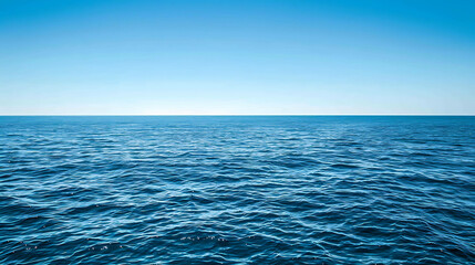 Obraz premium Deep blue ocean with a clear blue sky. The water is calm and there are no waves. The horizon is in the distance.