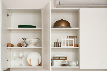 Open cupboards with utensils in kitchen