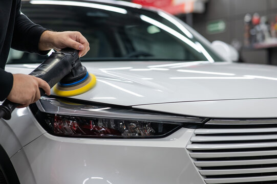 Fototapeta Process of polishing white car hood surface using orbital polishing machine. 