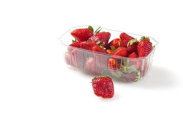 Ripe, red strawberries in a clear plastic container with a green stem. The container is sitting on a clean, white surface, showcasing the vibrant color and freshness of these delicious fruits.