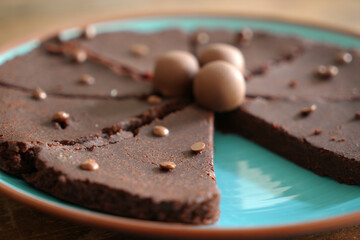 Detail of a fluffy chocolate cake with chocolate pieces and pralines on top