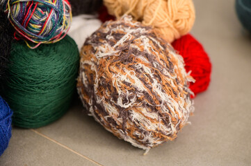 Colorful yarn balls scattered artistically, showcasing vibrant textures in a cozy crafting corner