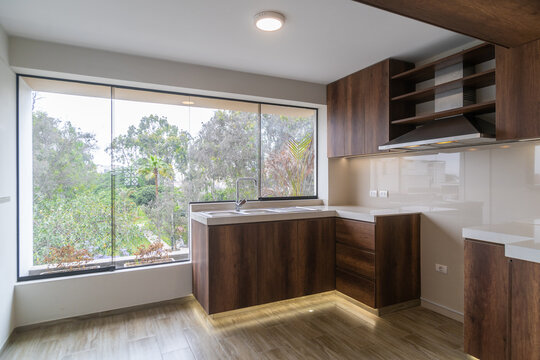 cocina amoblada con alancena ,estufa, muebles altos y bajos , acabados de madera e iluminada