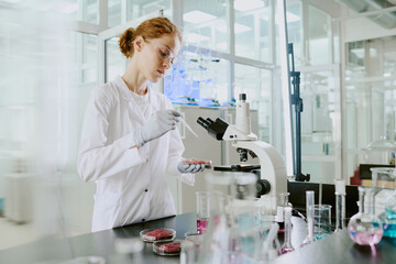Scientist conducting research in modern laboratory with advanced equipment, surrounded by test...