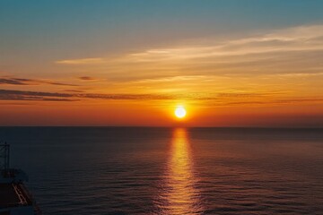 Stunning sunset photograph capturing an orange sky over the sea, with the sun gracefully setting on the horizon, showcasing a beautiful seascape view from above.