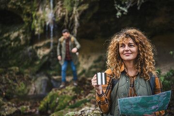 wife hold map and cup explore forest and find route on map