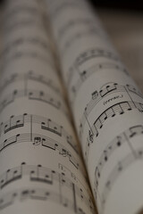 Sheet music rolls displaying intricate notes and musical symbols in a soft-focus setting, emphasizing creativity and artistry in music creation