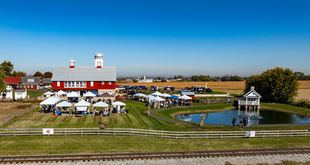A Picturesque Farm Setting in Autumn Featuring a Gathering by the Pond and Festive Tents