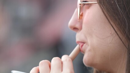 Pensive happy woman sipping a milkshake in the street