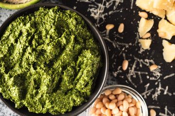 Homemade Pesto Sauce with Pine Nuts and Basil: Ingredients on Black Background