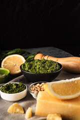 Homemade Pesto Sauce with Pine Nuts and Basil: Ingredients on Black Background