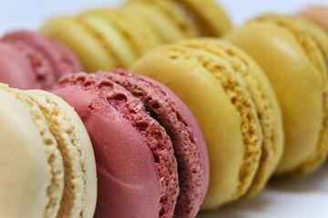 Close up of a selection of various flavours and colours French macarons on white background 