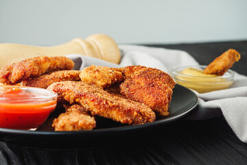 Crispy Chicken Strips with Spicy Sauces on a Rustic Wooden Background