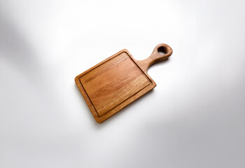Fototapeta premium A square wooden cutting board with a single handle.