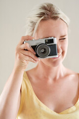 Photography, camera and portrait with woman in studio for director, cinematographer or production. Vintage, shooting and filmmaking project with person on white background for lens and focus