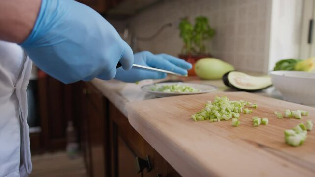 Chef Cuts Zucchini Vegetable On A Wooden Cutting Board In Restaurant Kitchen