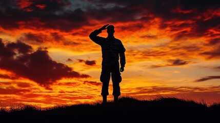 Silhouette of a Soldier Saluting Against a Fiery Sunset Sky.