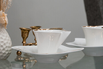 Elegant White Porcelain Teacup Set on a Glass Table with Decorative Elements